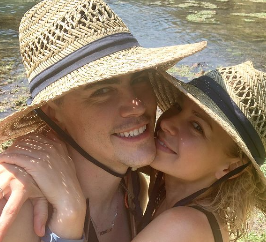 Tom Sandoval and Ariana Madix wear straw hats.