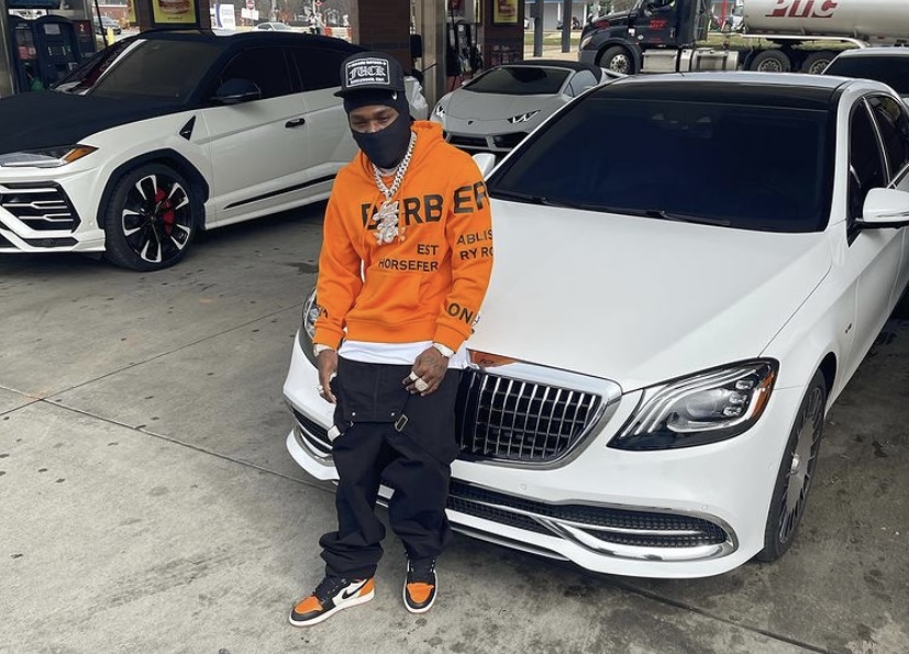 DaBaby in front of one of his cars.