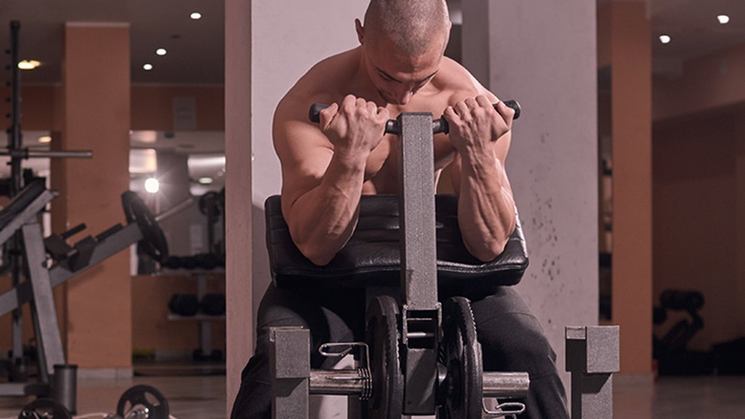 Individual performing a bicep curl with a machine