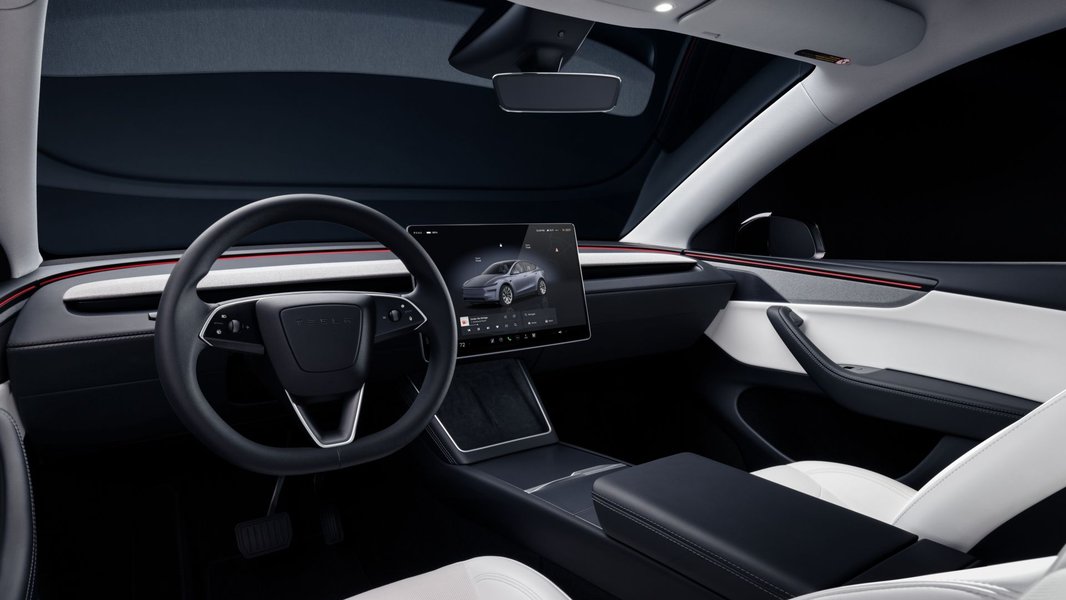 Interior of 2025 Tesla Model Y showing rear passenger touchscreen and ambient lighting