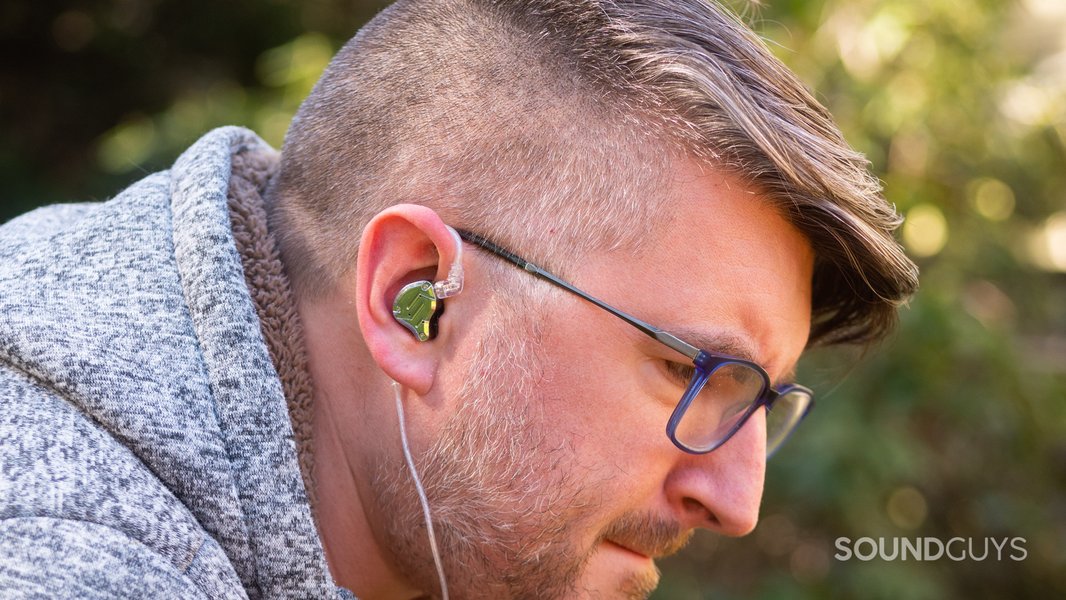 Person wearing IEMs, illustrating potential fit/isolation variance