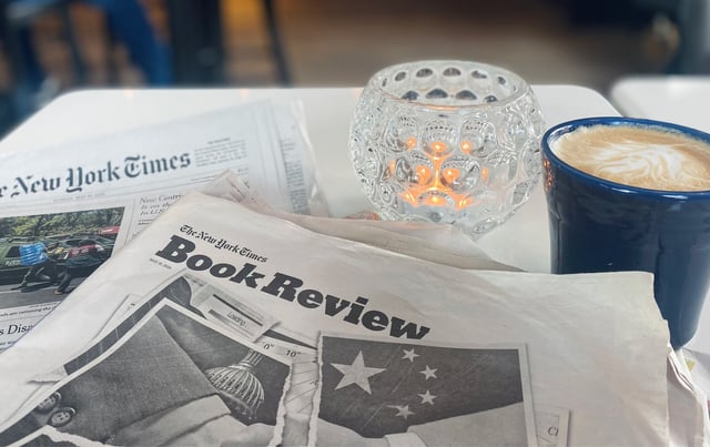 newspaper desk with physical books and coffee