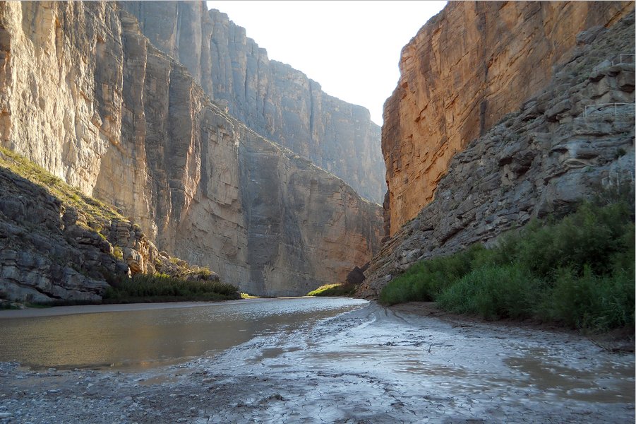 Aerial view of a river meandering through a canyon, illustrating how fluvial systems carve landscapes, a process significantly influenced by tectonic uplift.