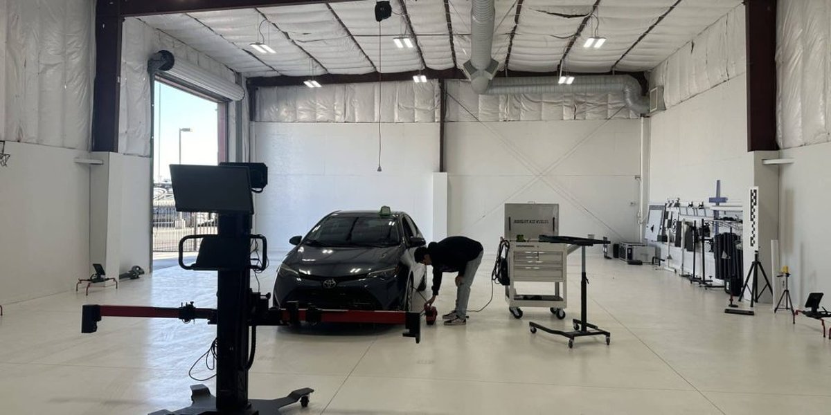 Indoor ADAS calibration bay with level floor, neutral walls, and OEM-specified targets.