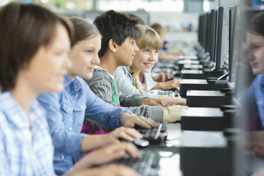 Young students engaged with computers, likely learning programming concepts.