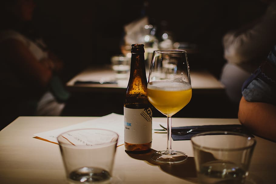 wine glass and beer bottle on table