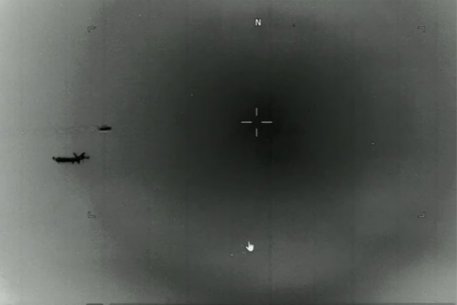 Military personnel looking at a screen with unidentified aerial phenomena, representing government interest in UAP reports.