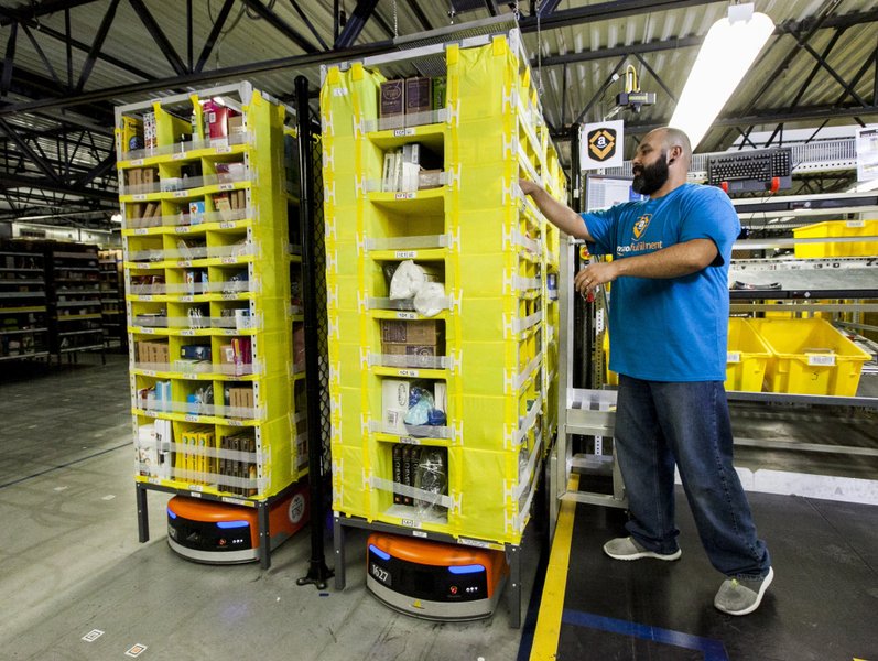 Interior view of a modern Amazon fulfillment center with packages on conveyor belts