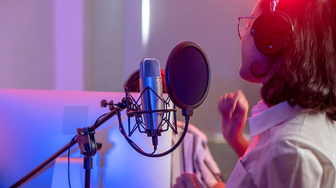 Une femme chantant dans un studio.