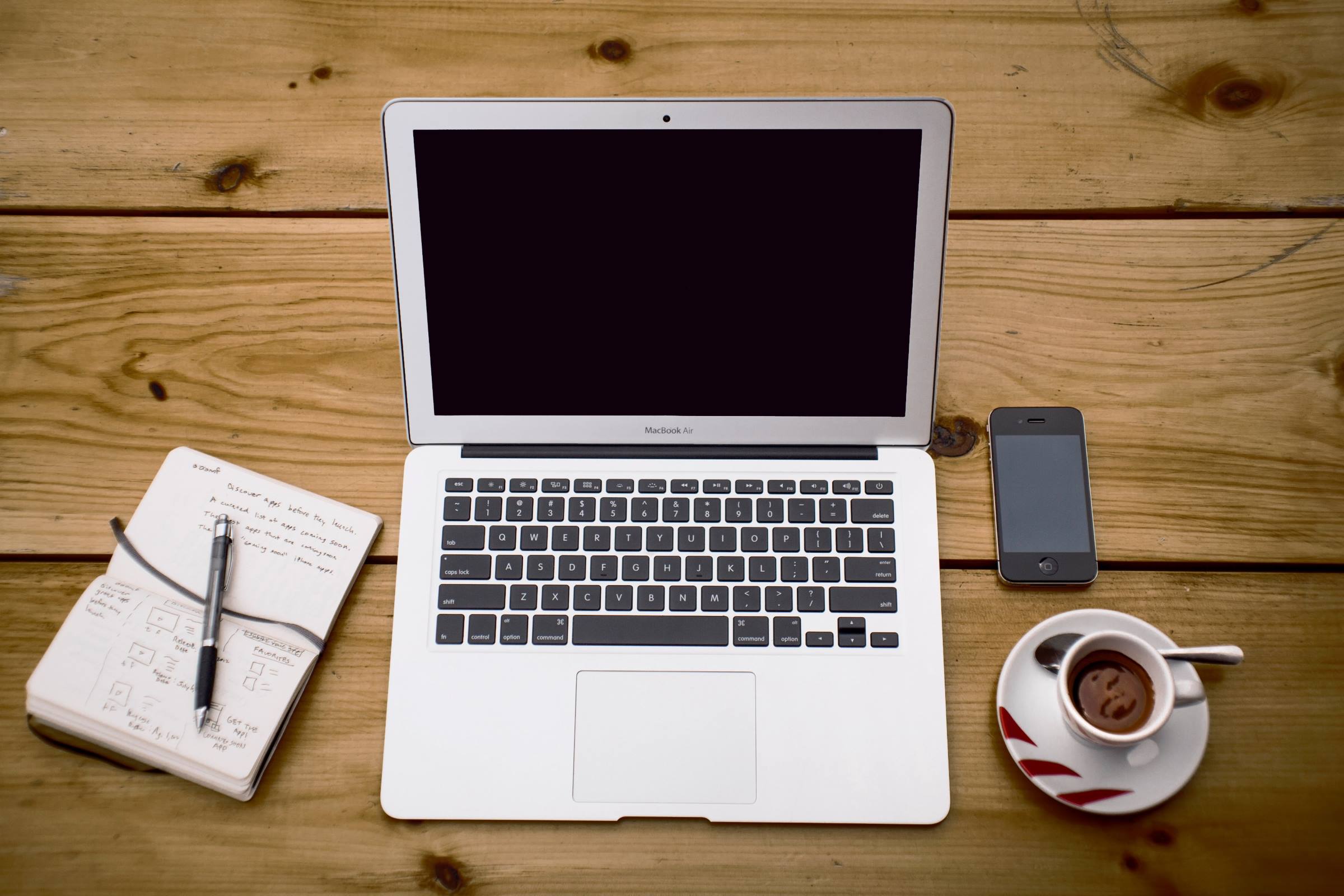 laptop, notepad, coffee cup on desk