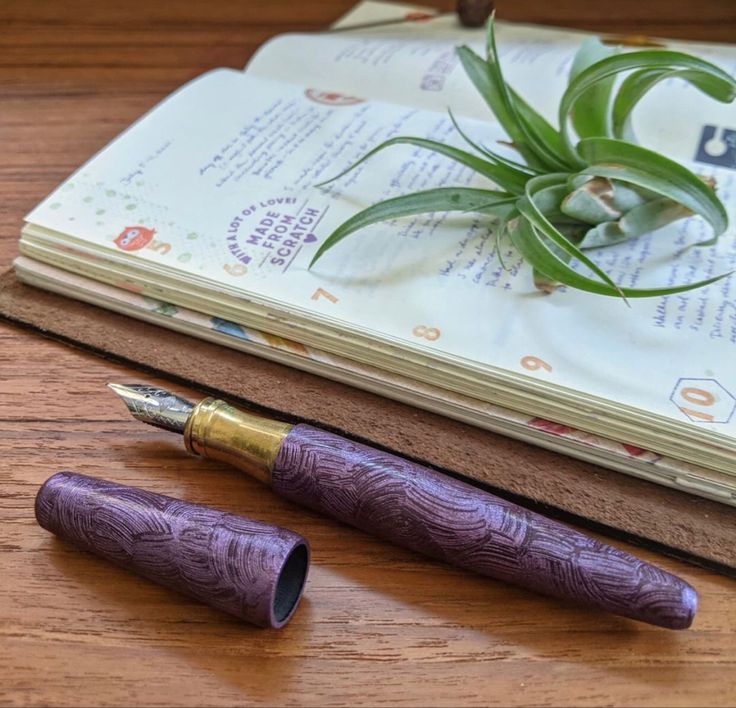 open book on wooden table with pen