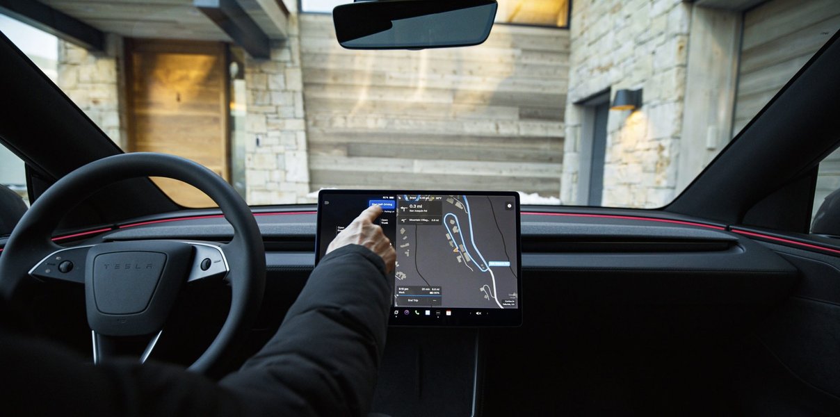 Tesla FSD Supervised display showing real-time road visualization.