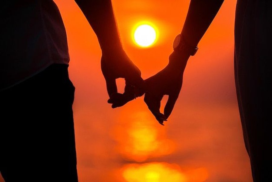 Silhouette of a couple holding hands at sunset on a beach