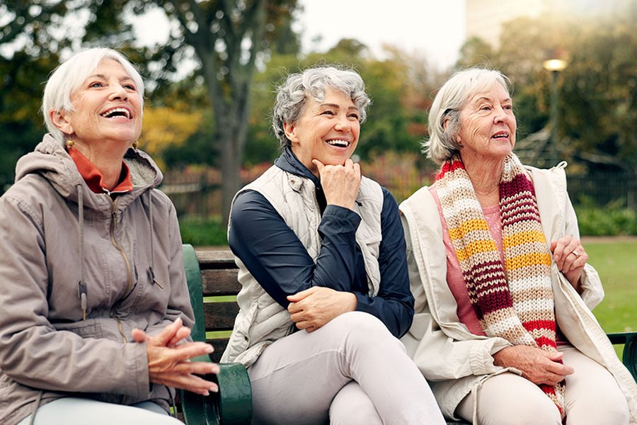 Two older women smiling and enjoying time together outdoors