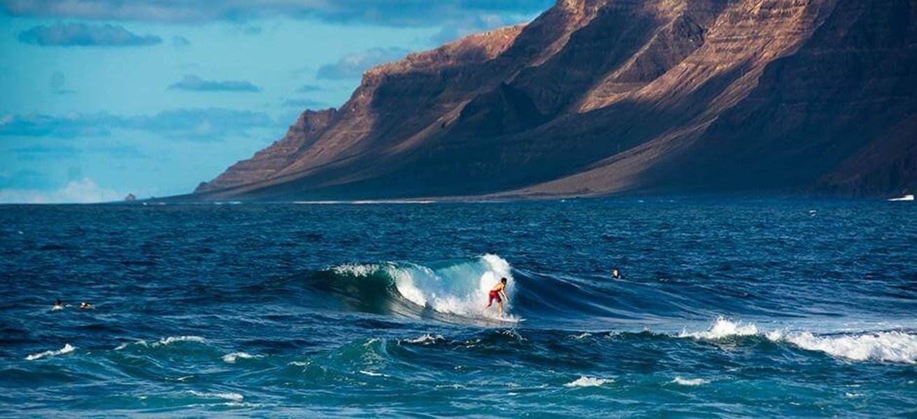 Surfer riding a left-hand wave at San Juan, Lanzarote