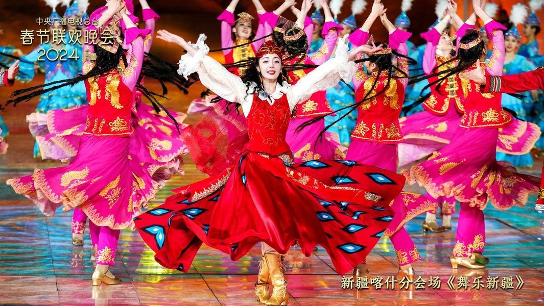 Performers in colorful traditional costumes dancing during a festival in Xinjiang