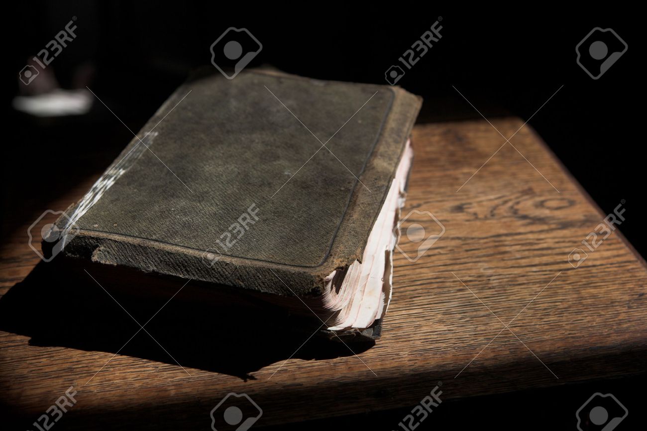 sunlit ancient scriptures on wooden table