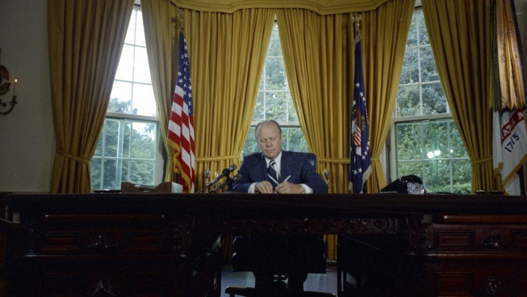 A president signing documents at a desk