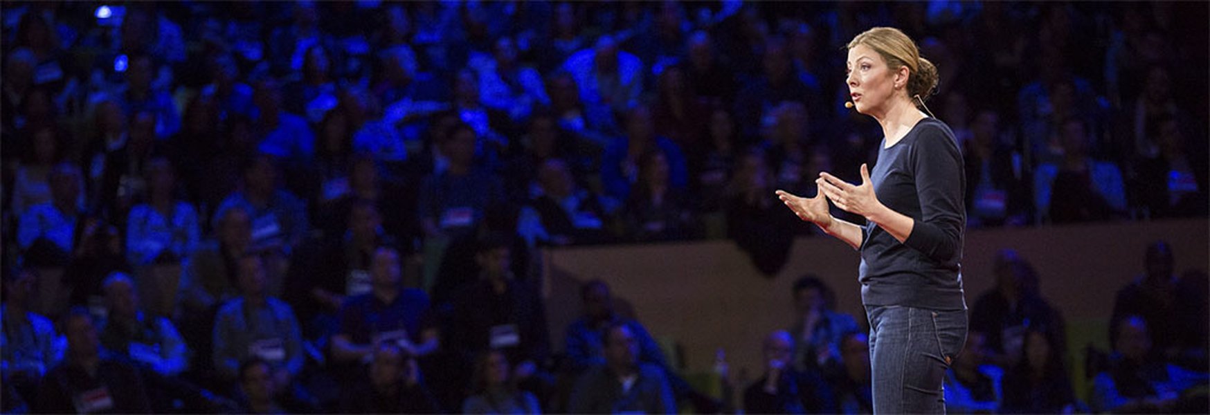 Person confidently speaking at a podium to an audience