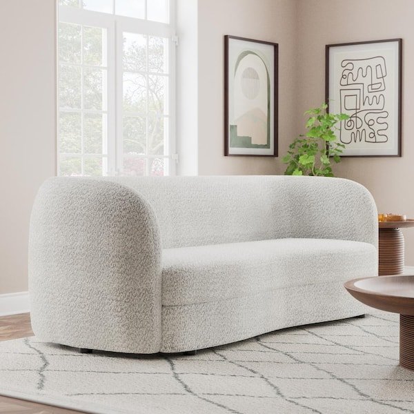 A white bouclé sofa with curved arms, offering a modern aesthetic.