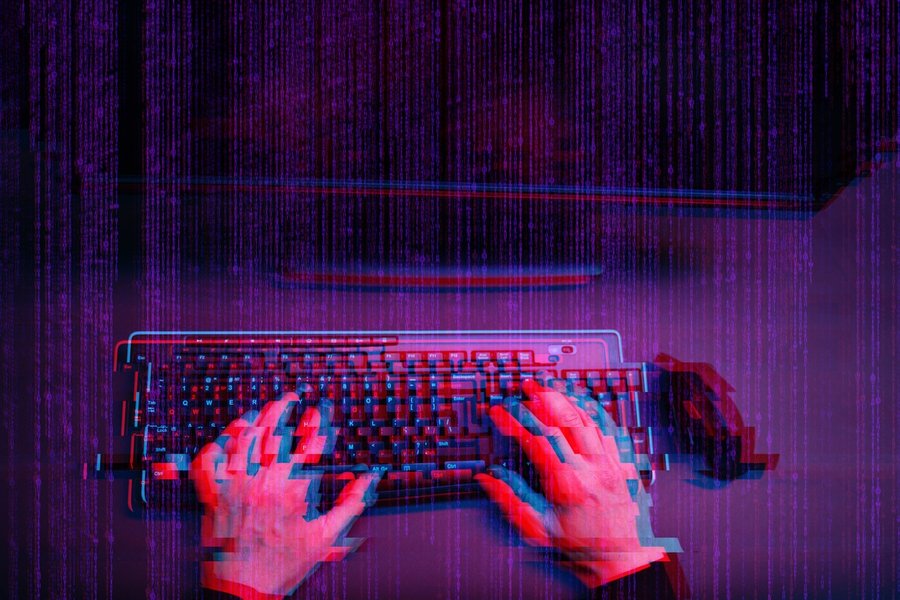 Conceptual image of a hacker working in a dark room
