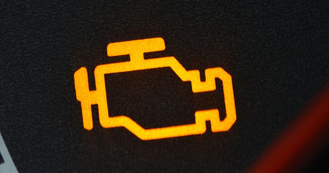 A yellow check engine light illuminated on a car dashboard.