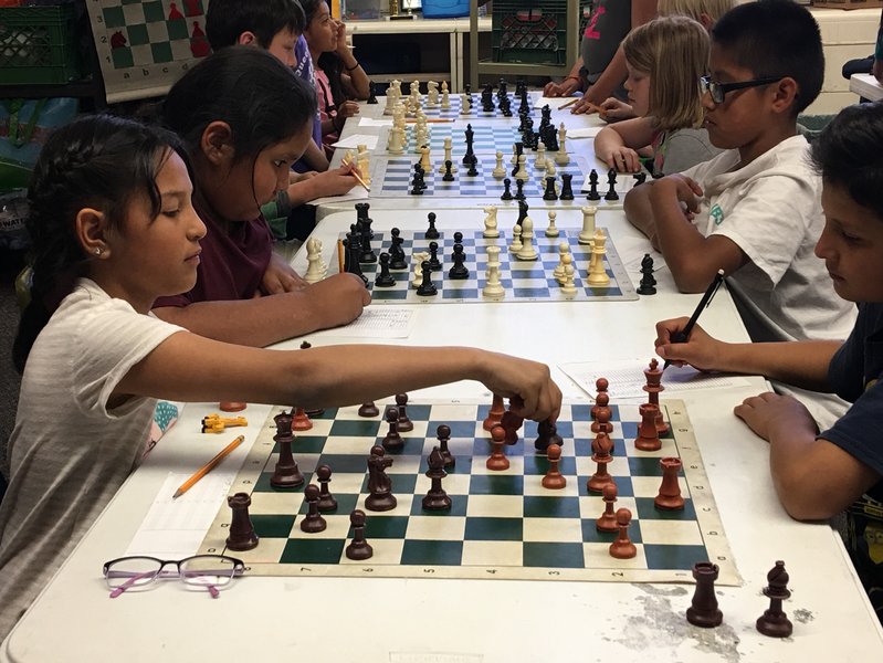 Students intently focused on their chess boards during a school tournament.