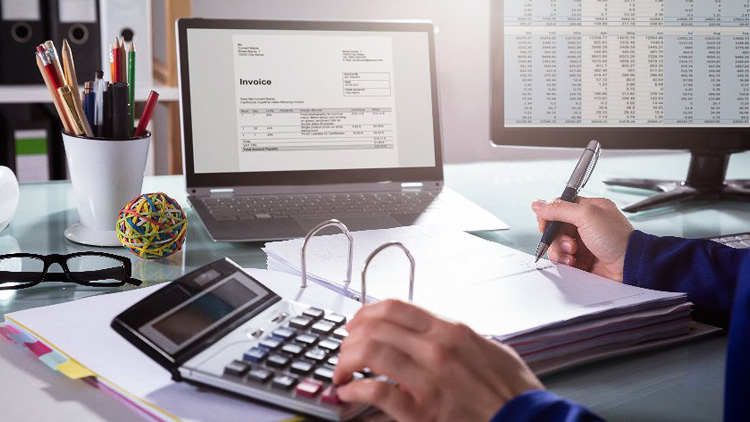 desk with invoices and calculator