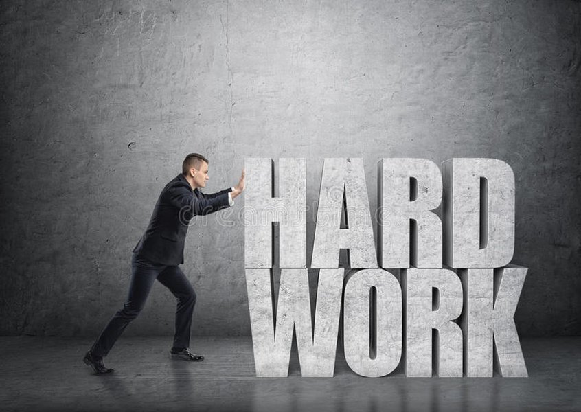 Silhouette of a person pushing a large stone uphill, symbolizing hard work