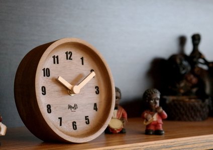 analog clock on wooden desk