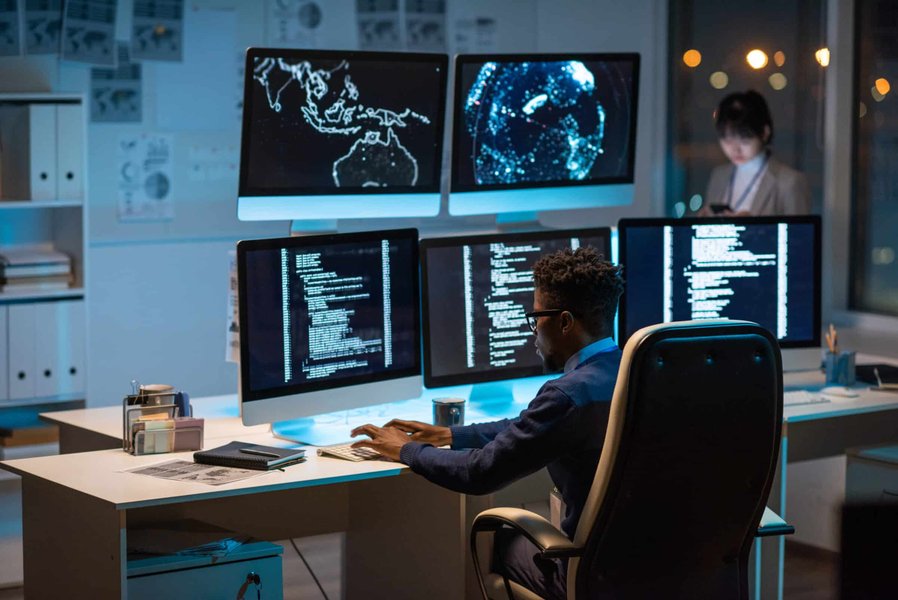 A cybersecurity manager diligently working on a laptop, representing the technical and strategic demands of the role.