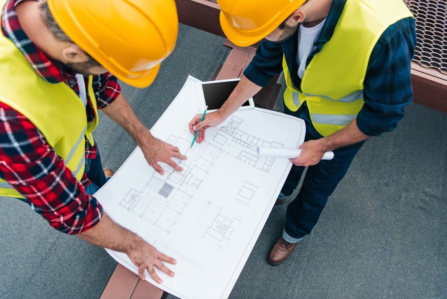 construction site with blueprint and workers