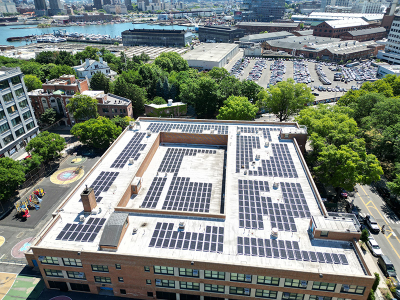drone shot of green cityscape with solar panels