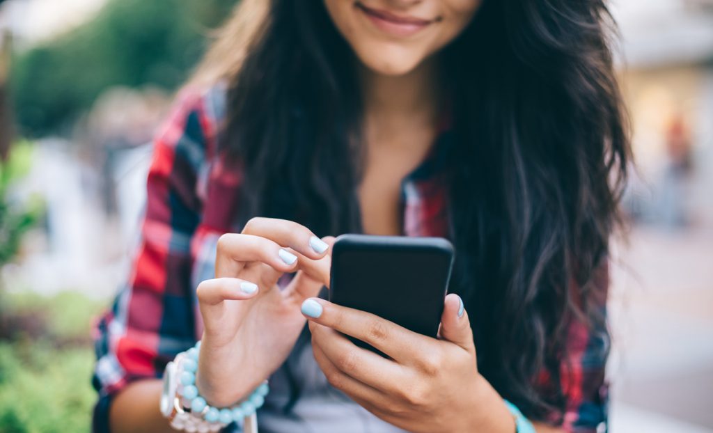 teen using smartphone outdoors