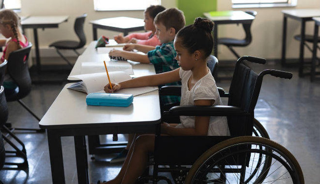 Persona en silla de ruedas participando activamente en un aula.
