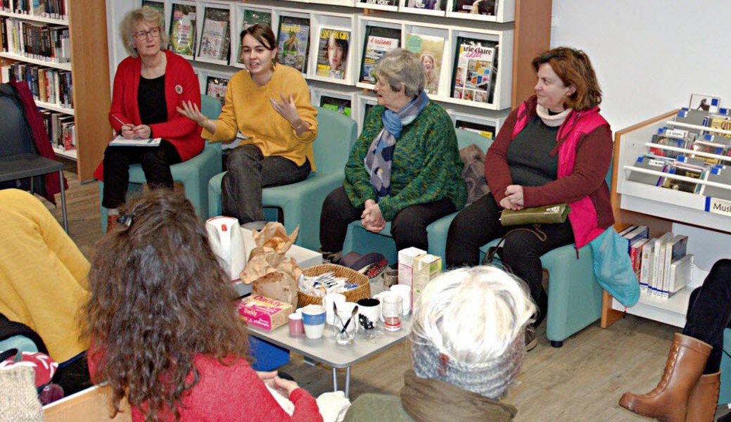 Groupe de lecteurs discutant autour d'une table avec des livres
