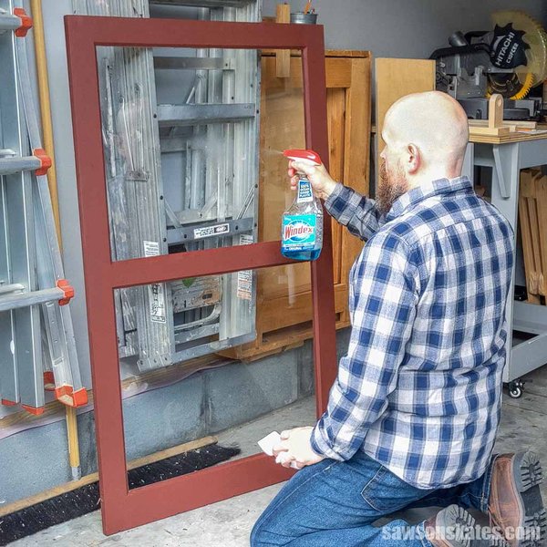 A wooden storm window frame with a pane of glass installed, showing the glazing and frame details.