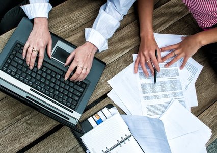 people editing documents at a computer
