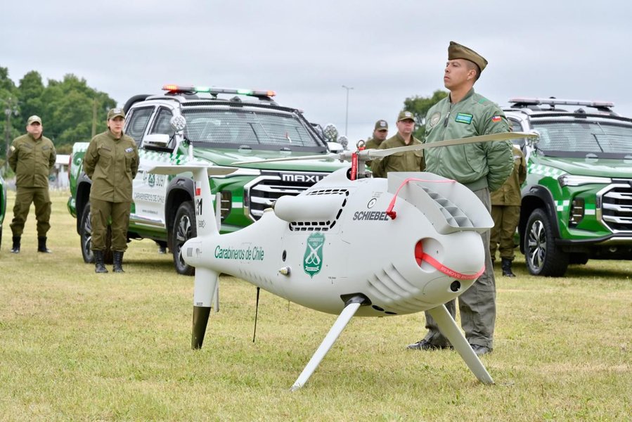 Un dron tipo Camcopter S-100 en un hangar o base de operaciones, con un rotor principal y tren de aterrizaje.