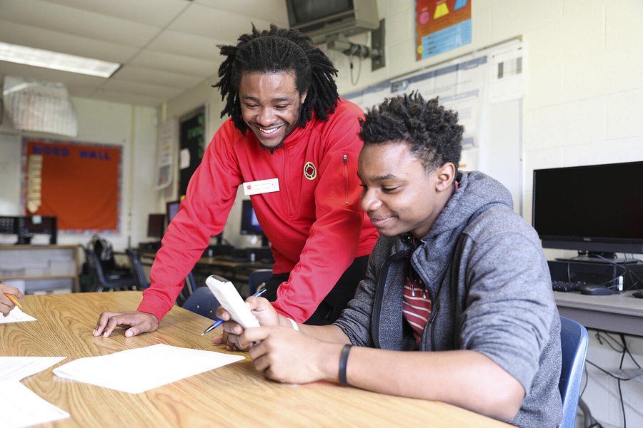Teacher and students working on math problems together