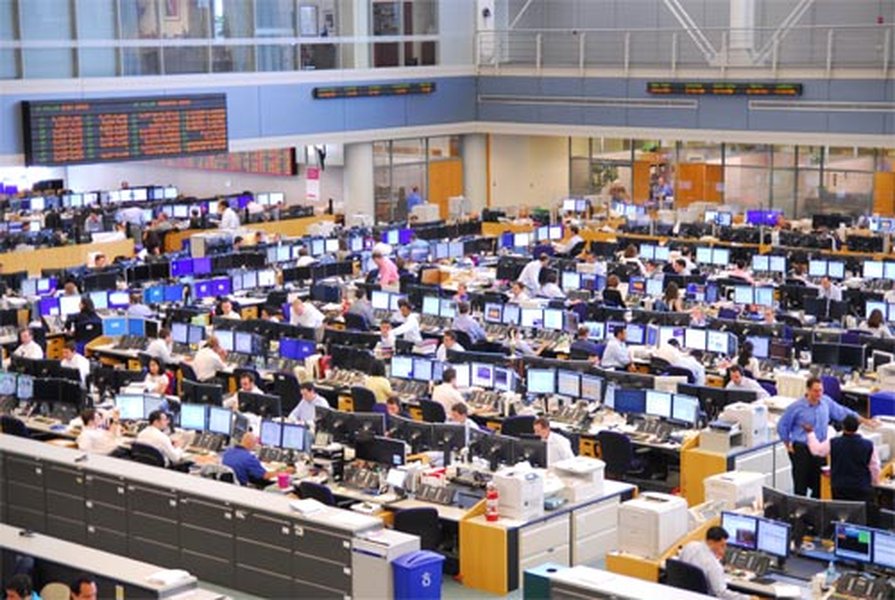 Busy trading floor with monitors showing financial data