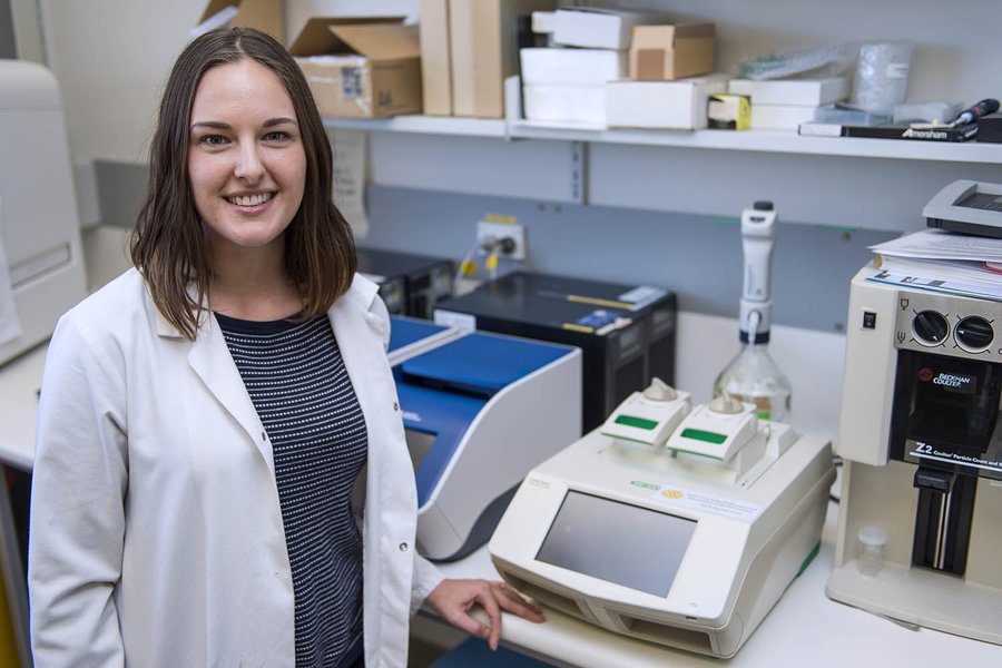 Scientist operating a PCR thermal cycler machine