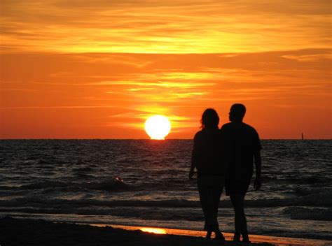 couple walking hand in hand sunset