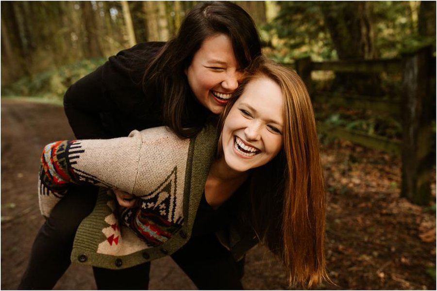 Two women smiling and holding each other close in an urban setting