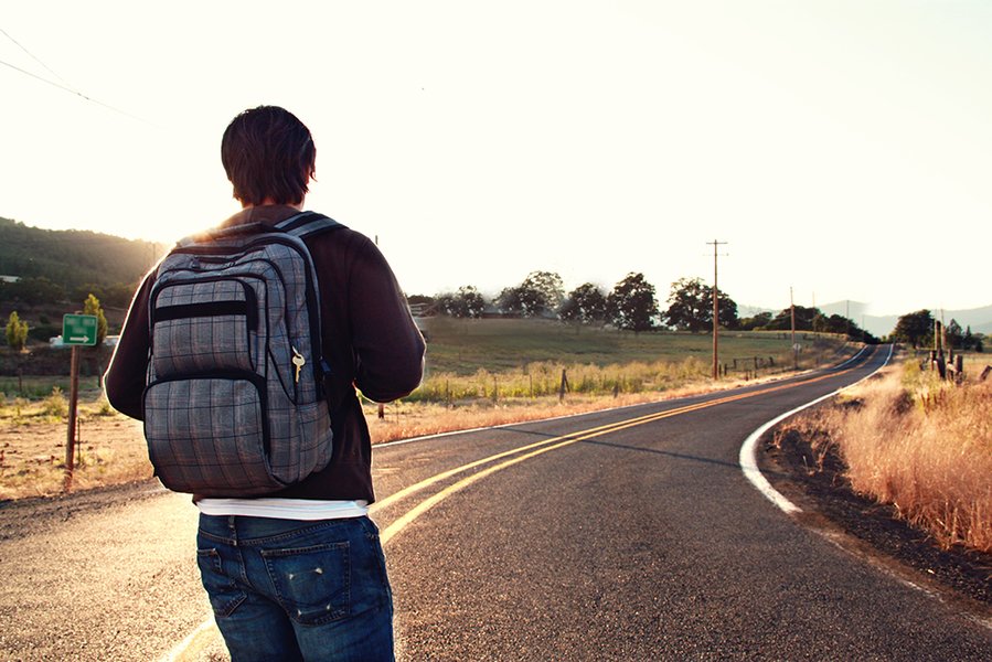 A person standing at a crossroads, looking towards a path ahead