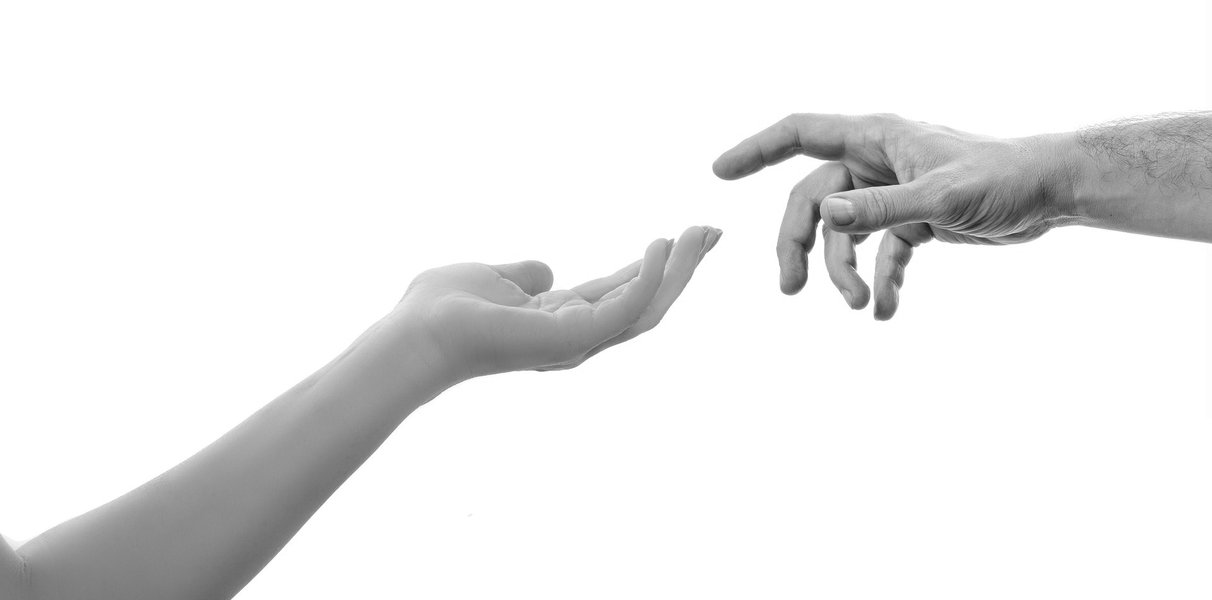Two hands reaching towards each other, symbolizing giving and receiving help.