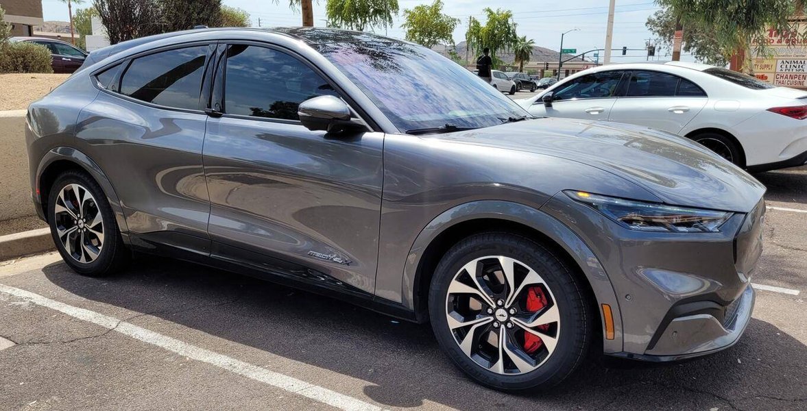 Ford Mach-E parked with hood open, showing the 12V battery area.