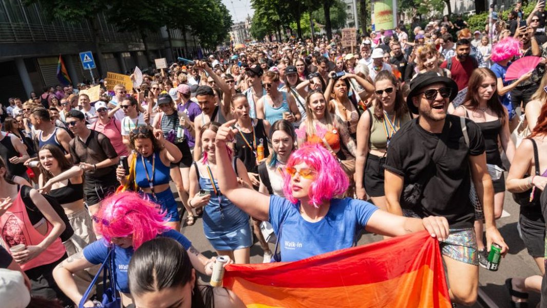 People marching in a Pride parade with flags