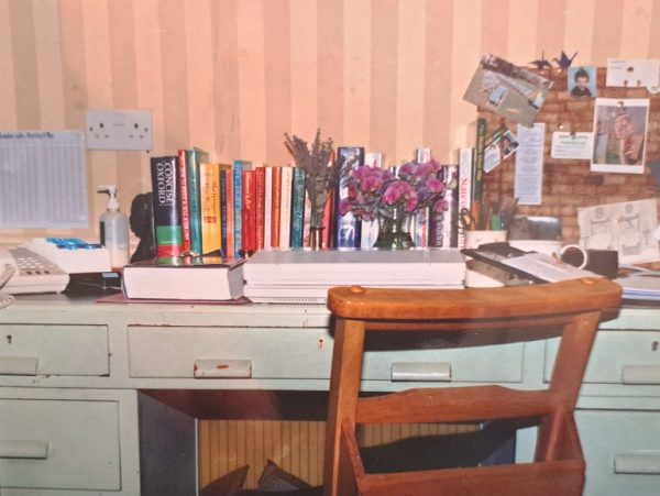 wooden desk with books and papers