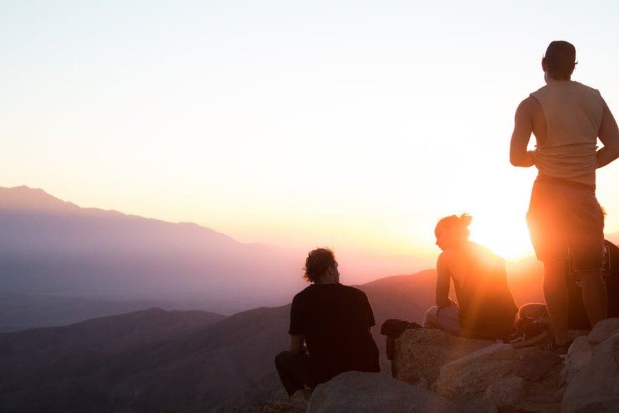 sunrise over mountains with people praying